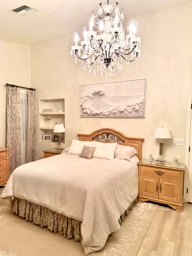 Customer's white Ocean Waves Abstract Wall Art displayed above the headboard in an elegant bedroom.