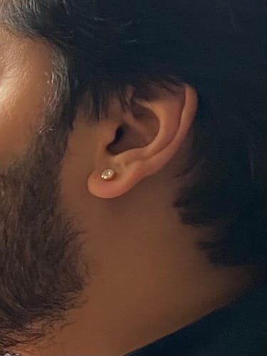 Close-up of a reviewer wearing the Golden Luminous Zircon Stud earring in their ear.