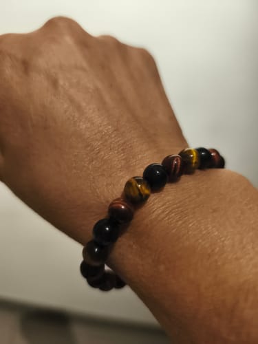Cliente portant à son poignet le bracelet "Oeil Multiple" aux perles marron, rouges et noires.
