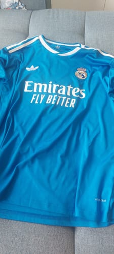 Avis d'un client : le maillot bleu à manches longues Third du Real Madrid posé sur un canapé.