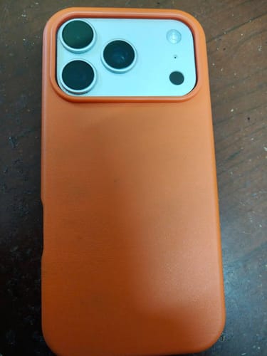 Customer's Ember Orange Signature Leather Magsafe Case fitted on the back of an iPhone.