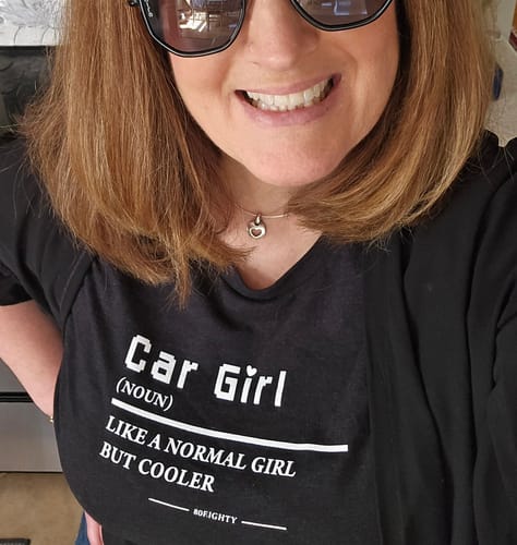 Customer wearing the black Women's Car Girl Shirt in a close-up view, showing the text graphic and relaxed fit.