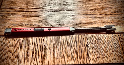 Customer's red 360 Degree Household Arc Lighter with a flexible neck, shown on a wooden surface.