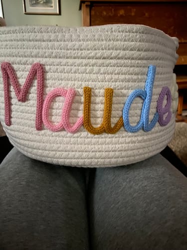 Customer's personalized white rope basket with the name 'Maude' in colorful yarn letters.