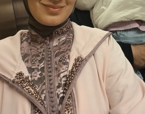 Close-up of a reviewer wearing the Jellaba Amara, showing the detailed beadwork and lace inner kaftan.