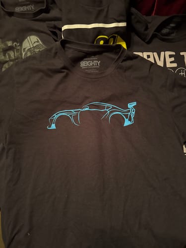 Customer's black 80Eighty DCG87 Shirt laid flat, showing the bright blue car outline on the chest.