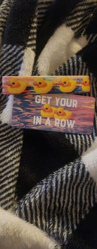Customer's 'Get Your Ducks In A Row' bracelet and its packaging card laid out on a fuzzy black and white plaid blanket.