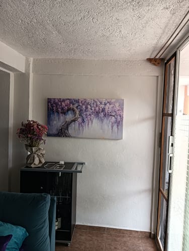 El cuadro Racimos Florales de un cliente, con colores intensos, colgado en la pared de una sala.