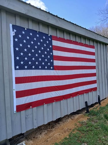 Customer's large American Nylon Flag displayed horizontally on the side of a building.