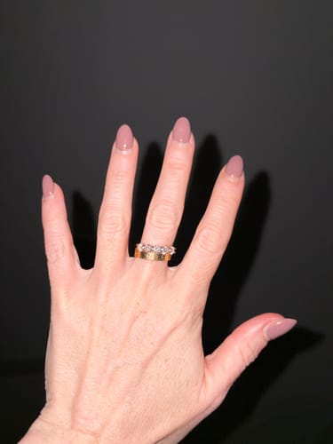 A reviewer's hand showing the Ingrid Moissanite Diamond Ring stacked with a plain gold band.