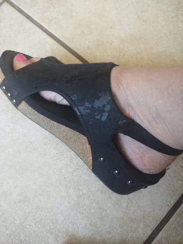 Customer's foot wearing the black Corky's Volta II Sandal, showing the cork platform and studded heel detail.