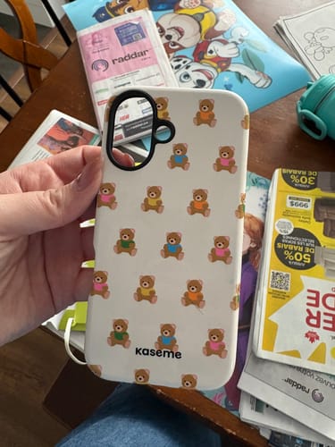 Customer holding their Mystery Funky case, a white phone case with a colorful teddy bear pattern.