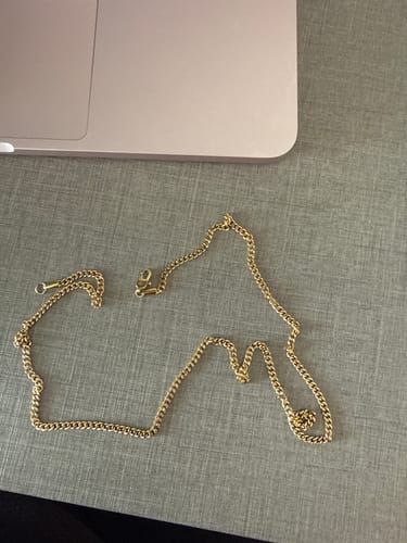 Cliente muestra la Cadena Miami Cuban Oro de 3mm desabrochada sobre una mesa.