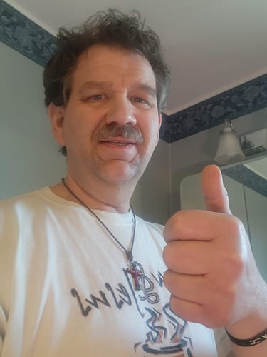 Reviewer giving an enthusiastic thumbs-up in a bathroom.