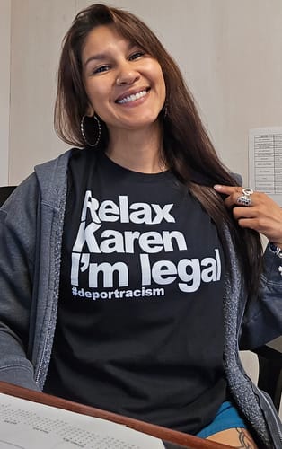 Customer smiling while wearing the black Relax Karen I'm Legal OG T-Shirt under a grey hoodie.
