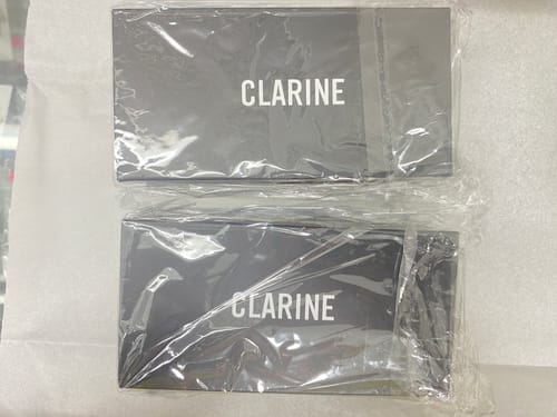 Packaging for the customer's two CLAIRE DE MAINS watches, with both black boxes sealed in plastic.