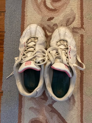 A reviewer's well-worn pair of white ST329 CMF sneakers with shocking pink accents, shown from a top-down view.