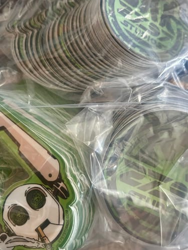 Close-up of a customer's order of custom vinyl stickers, with two different designs stacked in plastic bags.