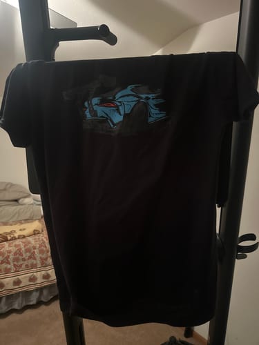 Customer's black 80Eighty DCG87 shirt with a blue car graphic hanging up indoors.