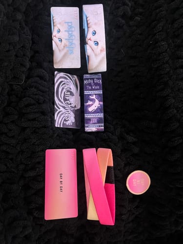 Reviewer's items from a Subscription Mystery 3-Pack, showing three unique straps with their collector cards and a pin.