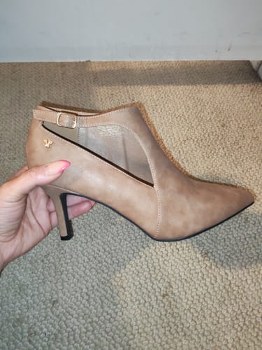 Reviewer holding the taupe Butterfly Feet Lively heel, showing the pointy toe and side cutout detail.