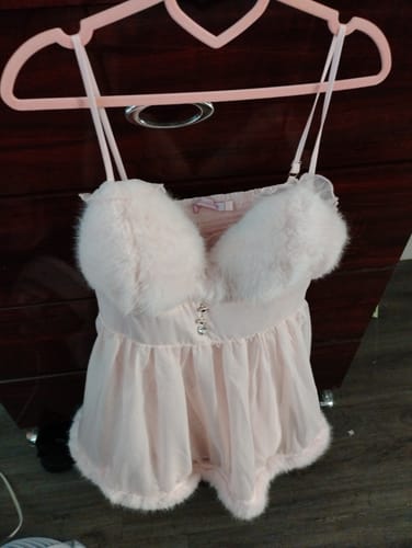 Customer's pink Rosé Princess babydoll dress with fluffy fur trim hanging on a heart-shaped hanger.