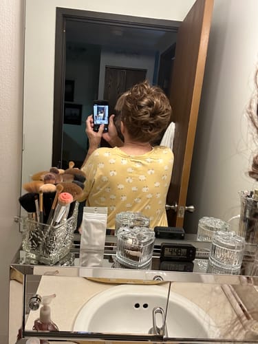 Reviewer's mirror selfie showing the back of their head with the light brown JuvaBun Messy Bun.
