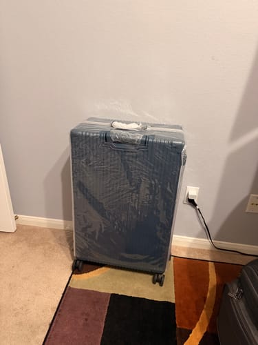 Customer shows their blue luggage protected by the transparent Luggage Cover.