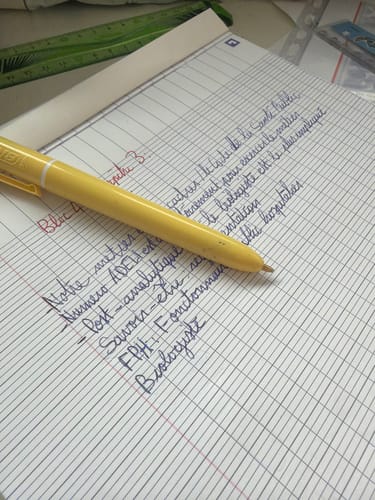 Client écrivant des notes sur le bloc-notes quadrillé Oxford avec un stylo.