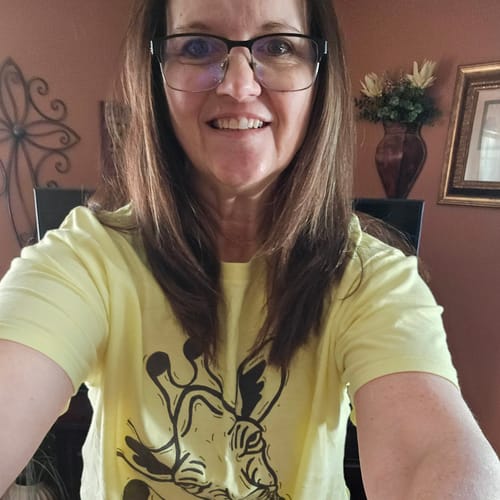 Reviewer wearing a light yellow t-shirt with a black, stylized giraffe graphic.