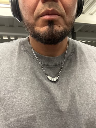 Customer wearing the necklace from the Legacy Set of 2, showing the silver chain and small pendants.