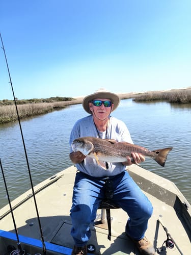 Reviewer on a boat holding a large redfish caught with the Marker 54 Jerk Shrimp lure.