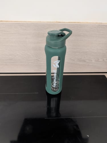 Le GreenShaker 2.0 vert d'un client, posé sur une plaque de cuisson noire, avec sa boule de mélange visible.