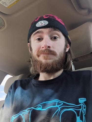 Reviewer wearing the black 80Eighty® DCG87 Shirt with a bright blue car graphic on the front.