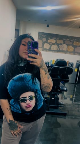 Cliente se toma una selfie en el espejo luciendo la camiseta negra Paco Amoroso BIG HEAD.
