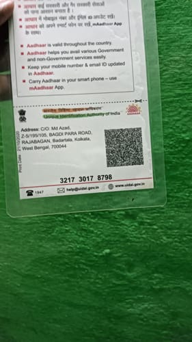 Reviewer holding a laminated document against a green background.