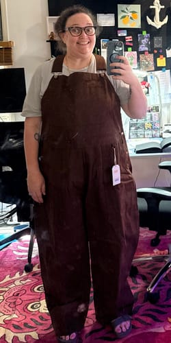 Reviewer smiling while wearing the dark brown Canvas Brumby Suit in a full-length photo.