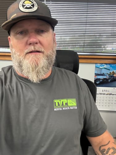 Reviewer in a gray T.V.P. Elite Membership t-shirt with a green 'Mental Health Matters' graphic.