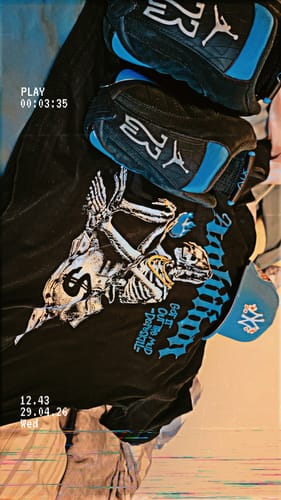 Reviewer's black DopeSkill graphic t-shirt displayed with matching blue and black sneakers and a cap.
