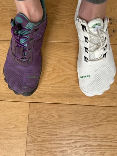 Reviewer wearing a new white Free Ⅰ - Barefoot Shoe next to an older, purple shoe for a side-by-side comparison.