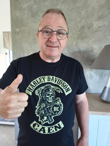 Client satisfait portant le T-shirt noir Faucheuse HC et faisant un pouce en l'air.
