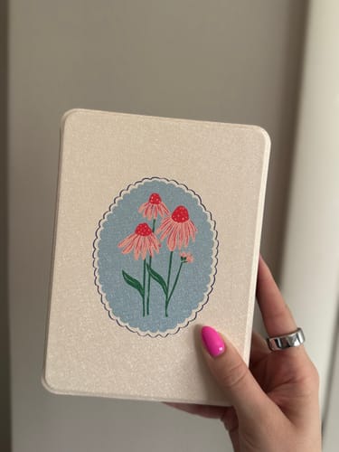 Reviewer holding the Summer Petal Kindle Case, showing the pink floral design.