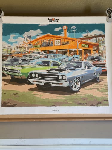 Customer's completed paint-by-numbers canvas showing a colorful vintage car scene.