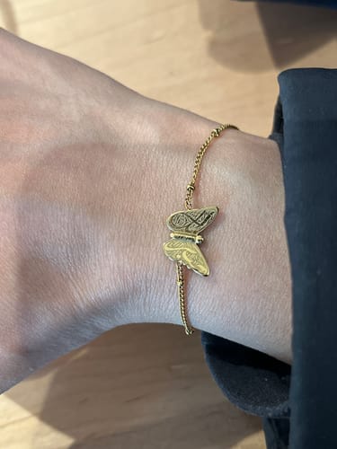 Reviewer wearing the gold Patience & Hope Bracelet with its engraved butterfly charm on their wrist.