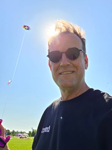 Reviewer smiling while wearing the black CHERRY BLOSSOM TEE outdoors on a sunny day.