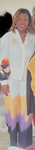 Reviewer standing and smiling while wearing the abstract printed pants, showing the full length and fit.