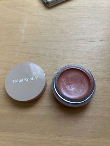 レビューアーによる、「HAPA Gleam Glow リップアンドチーク #502 ウォームシナモン」。蓋を開けた状態で、温かみのあるバームの色が見える。