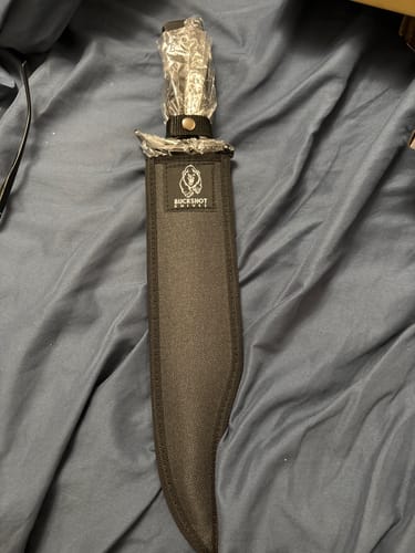 Customer's Vandal Fixed Blade knife shown inside its black nylon sheath, with the handle still in its protective plastic wrap.