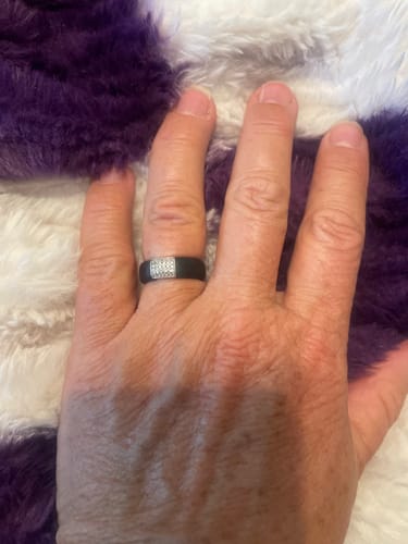 Customer's hand wearing the black silicone ring with a rectangular stone setting.