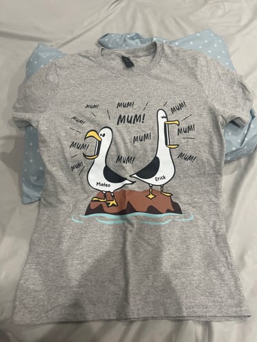 Customer's grey personalised Seagull Mum shirt laid out, showing two cartoon seagulls with the custom names 'Mateo' and 'Erick'.